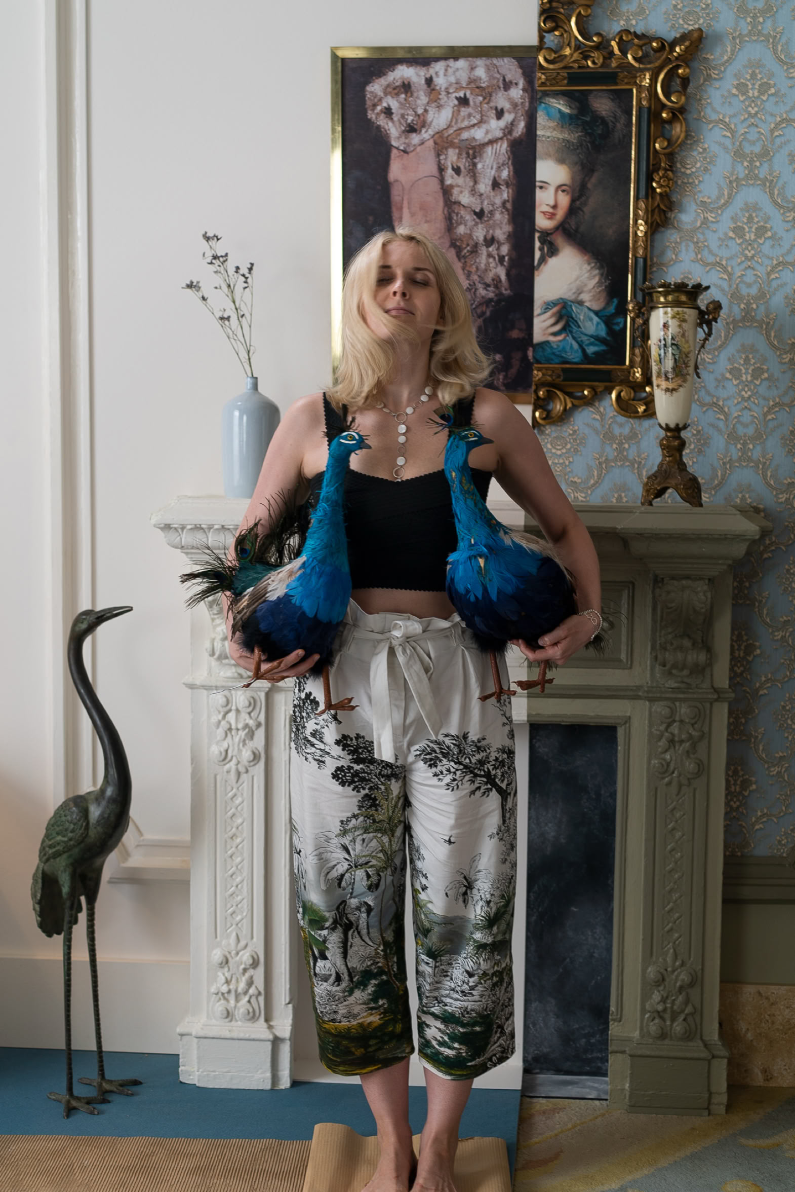 Set and props: model with two peacocks in a period interior